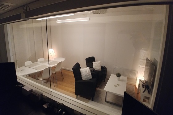 Picture through one-way mirror into large test room, set up as a living room